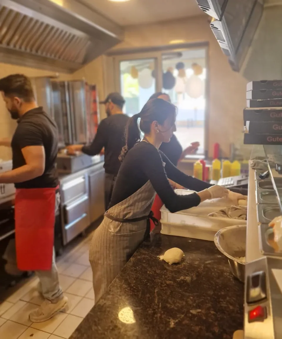 Mitarbeiterin bereitet einen Döner an der Theke zu